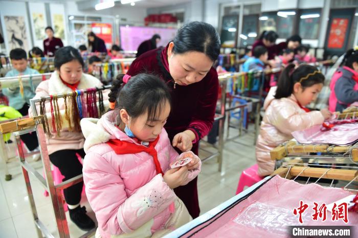 江西省級非遺豫章繡傳承人手把手指導(dǎo)小學(xué)生繡制2022年北京冬奧會吉祥物“冰墩墩”形象?！∮髟屏?攝