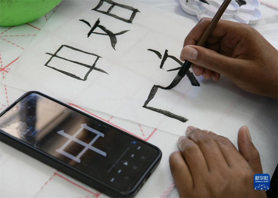 4月18日，肯尼亞學(xué)生在內(nèi)羅畢大學(xué)孔子學(xué)院舉辦的活動(dòng)上寫(xiě)毛筆字?？夏醽唭?nèi)羅畢大學(xué)孔子學(xué)院18日舉辦“中文，增進(jìn)文明對(duì)話(huà)”主題活動(dòng)，慶祝即將到來(lái)的第14個(gè)聯(lián)合國(guó)中文日?？夏醽唽W(xué)生參與互動(dòng)，進(jìn)行書(shū)法、剪紙、唱中文歌等活動(dòng)。新華社記者 韓旭 攝