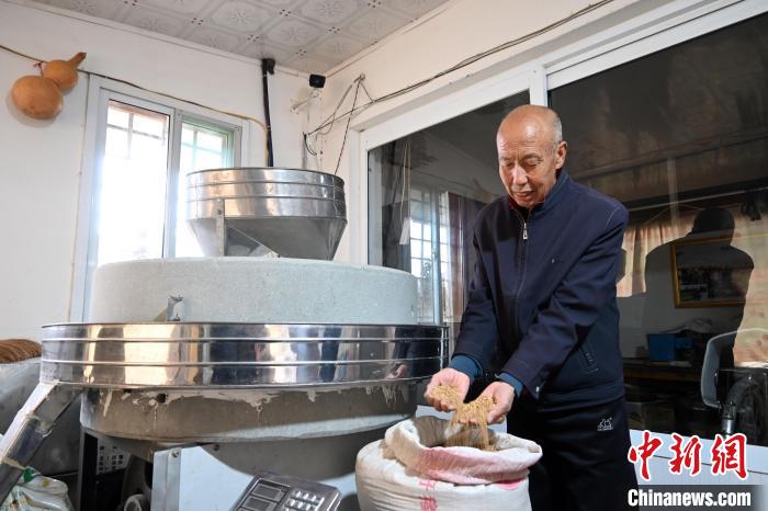 李家莊村民谷文朝重拾父輩的手藝，做起石磨面粉的營生?！〉杂鸺?攝