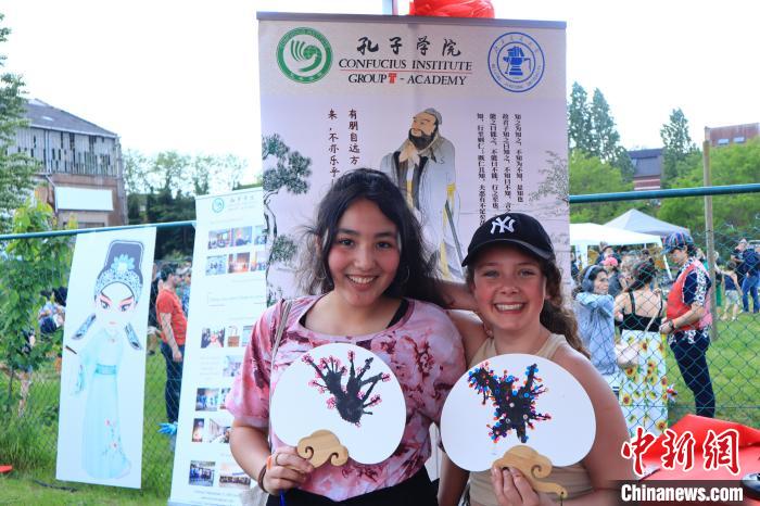 孩子們展示自己的吹墨畫團扇作品?！◆斻肟鬃訉W(xué)院供圖