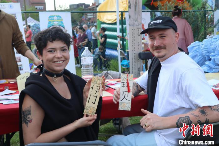 當(dāng)?shù)孛癖娫跐h字體驗工作坊展示自己手寫的中文名書簽?！◆斻肟鬃訉W(xué)院供圖