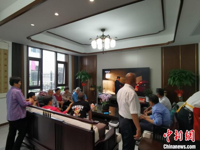 親友們集中在費(fèi)俊龍家中觀看返程的視頻?！＄娚?攝