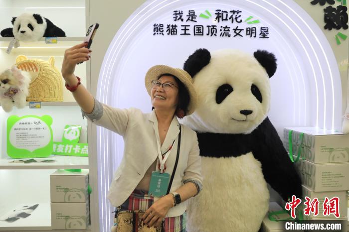 美國華視總裁楊蓮花與大熊貓文創(chuàng)產(chǎn)品合影。　王磊 攝