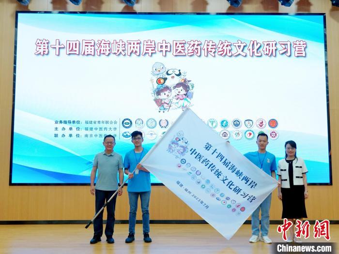 共青團福建省委副書記吳雪(右一)、福建中醫(yī)藥大學黨委副書記林羽(左一)為兩岸學生代表頒授營旗?！≡S燁婷 攝