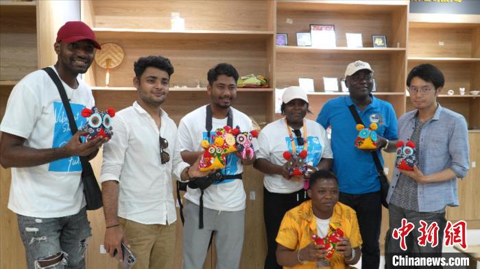 圖為國際青年代表展示親手制作的東營非遺黃河口布偶 ?！↓R魯 攝