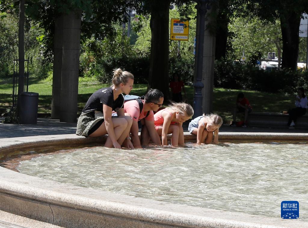 7月8日，人們?cè)诘聡?guó)法蘭克福的一處噴泉玩水。近日，德國(guó)法蘭克福逐漸迎來(lái)暑熱天氣。新華社記者 張帆 攝