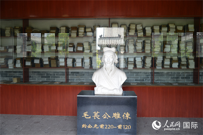 河間詩(shī)經(jīng)齋毛萇雕像。雕像后書櫥中陳列的是歷代各版本《詩(shī)經(jīng)》及譯本。 人民網(wǎng) 趙昭攝