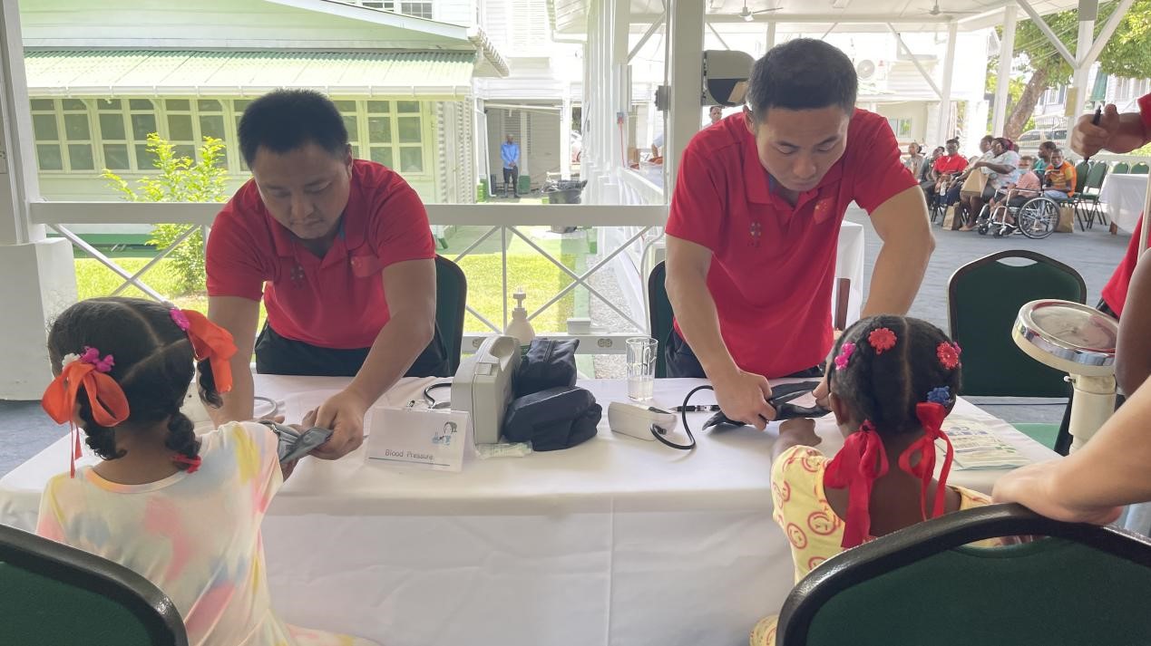 醫(yī)療隊(duì)員為福利院兒童進(jìn)行檢查。第18期援圭亞那醫(yī)療隊(duì)供圖