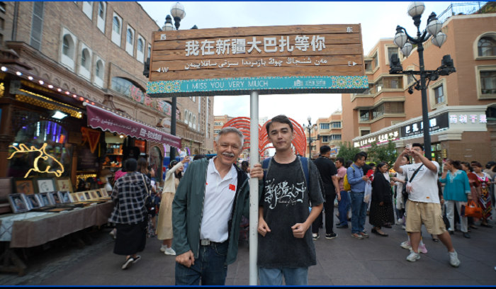 潘維廉和維吾爾族青年伊木蘭“打卡”大巴扎。主辦方供圖