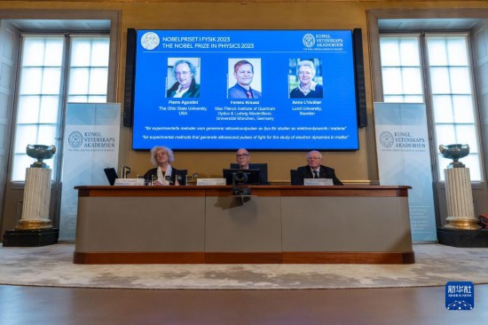 10月3日，在瑞典斯德哥爾摩舉行的2023年諾貝爾物理學(xué)獎公布現(xiàn)場，屏幕上顯示獎項(xiàng)得主皮埃爾·阿戈斯蒂尼（左）、費(fèi)倫茨·克勞斯（中）和安妮·呂利耶的照片。新華社發(fā)（魏學(xué)超攝）