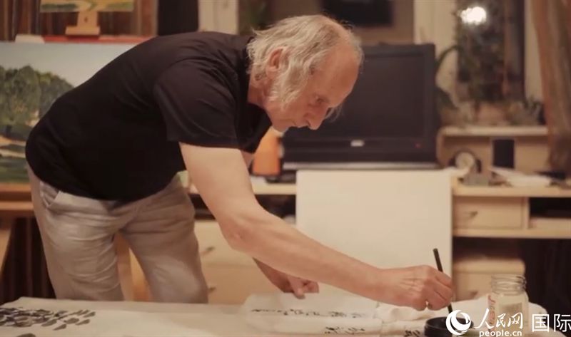 伊戈爾·布爾東諾夫在畫作上題詞。人民網記者 馬天翼攝