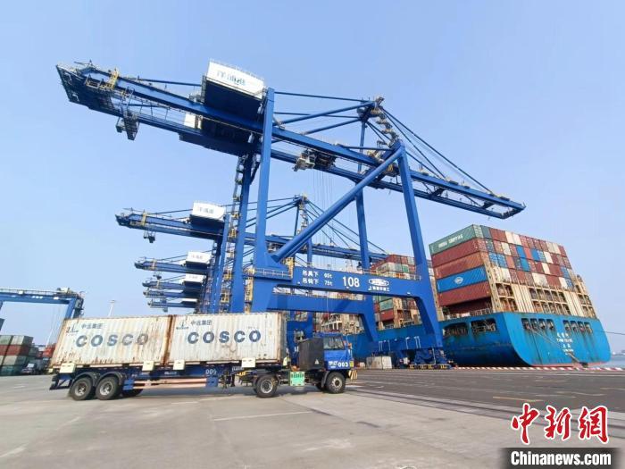 圖為海南洋浦國(guó)際集裝箱碼頭，卡車將集裝箱從后方堆場(chǎng)運(yùn)往碼頭裝卸區(qū)。　張?jiān)潞?攝