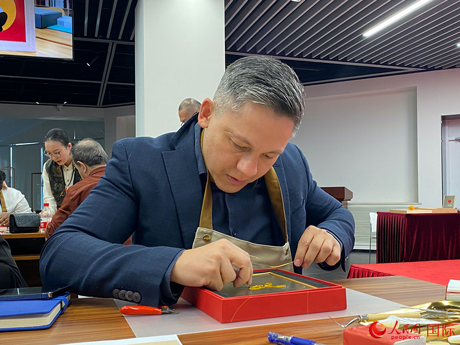 2023“一帶一路”媒體合作論壇聯(lián)合采訪團(tuán)團(tuán)員，親身體驗(yàn)景泰藍(lán)工藝。人民網(wǎng)記者 于洋攝