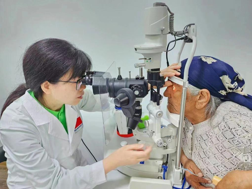 北京大學人民醫(yī)院眼科醫(yī)生鮑永珍正在為中亞白內障患者進行眼部檢查。（北京大學人民醫(yī)院供圖）