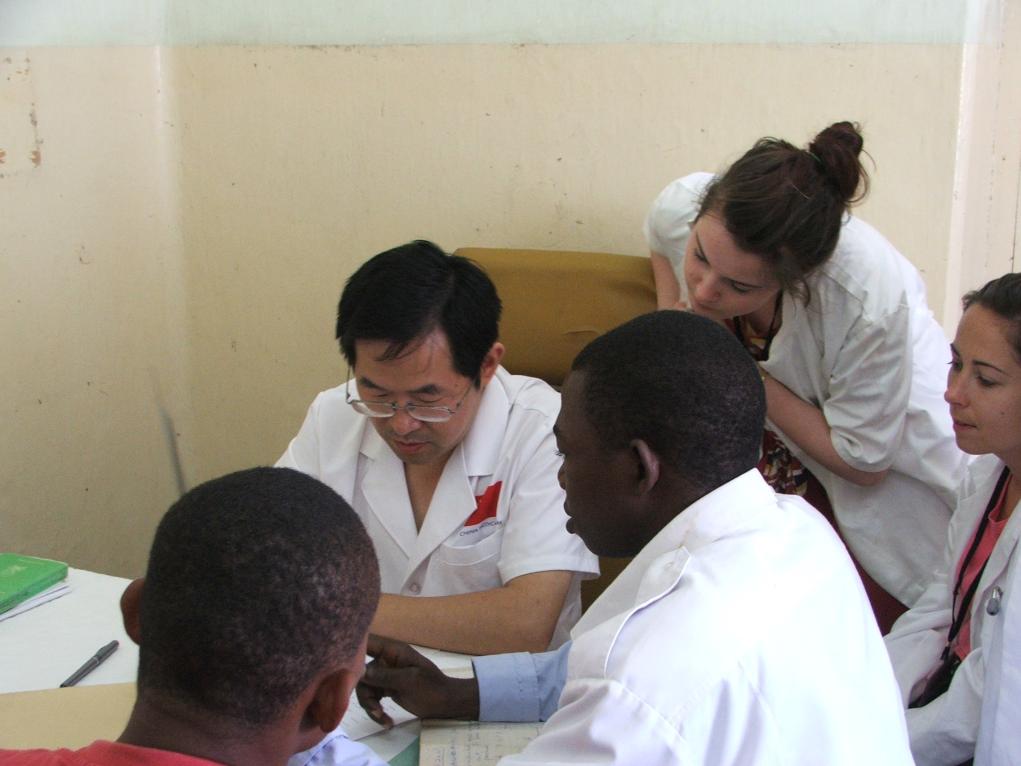 2011年7月22日，在坦桑尼亞桑給巴爾納茲莫加醫(yī)院外科門診，中國第24批援桑給巴爾醫(yī)療隊隊長盧建林為當?shù)鼗颊咴\治并帶教實習生。新華社發(fā)（國家衛(wèi)生健康委供圖）