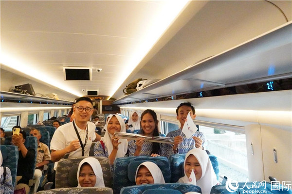 第一次乘坐雅萬高鐵動(dòng)車組的學(xué)生們與動(dòng)車組模型合影。人民網(wǎng)記者曹師韻攝