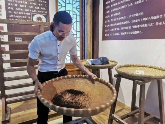 2023“一帶一路”媒體合作論壇聯(lián)合采訪團(tuán)團(tuán)員在非遺文化展示館體驗中藥炮制技藝。（本報記者 黃超攝）