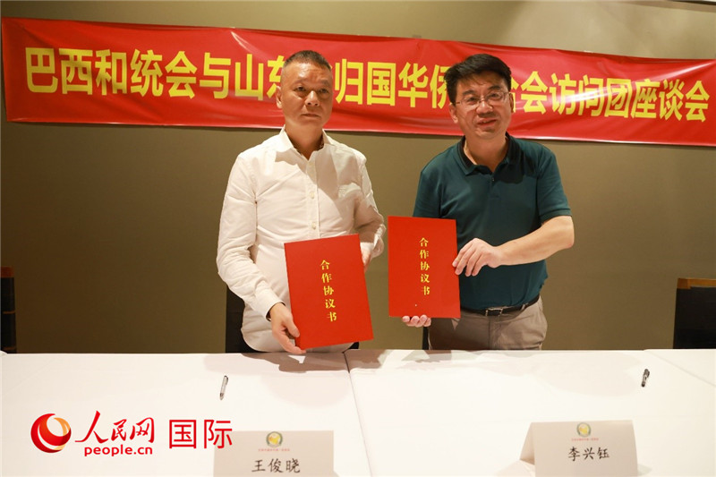 中國僑聯(lián)副主席、山東省僑聯(lián)主席李興鈺（右）與巴西和統(tǒng)會(huì)會(huì)長王俊曉簽署合作協(xié)議書。人民網(wǎng)記者 陳海琪攝