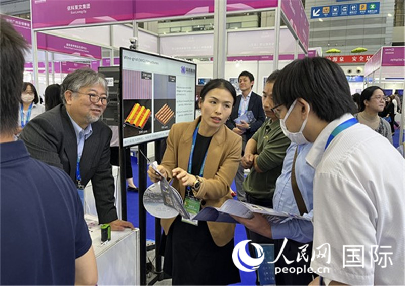 工作人員向參觀者介紹超級噴墨技術(shù)。（人民網(wǎng)記者 陳思攝）