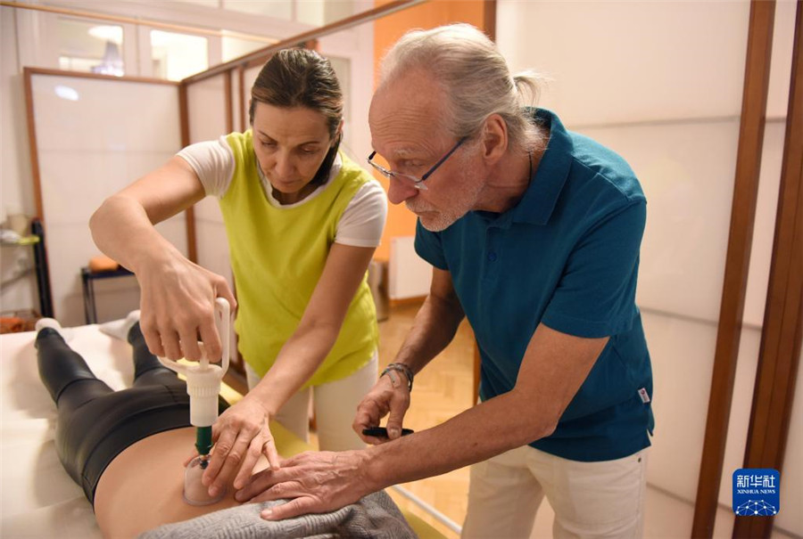 12月12日，在奧地利維也納，科格勒醫(yī)生（右）和助手在為病人進(jìn)行拔罐治療。新華社記者 賀燦鈴 攝