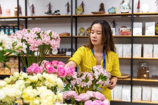 2023年7月1日，在位于湖南省長沙市的湖南高橋大市場，中非經(jīng)貿(mào)博覽會常設(shè)展館展區(qū)肯尼亞館工作人員在整理產(chǎn)自非洲的鮮花。新華社記者 陳思汗 攝