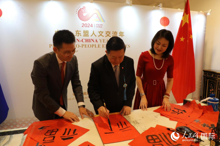 東盟秘書(shū)長(zhǎng)高金洪（中）在活動(dòng)現(xiàn)場(chǎng)寫(xiě)福字。人民網(wǎng)記者曹師韻攝