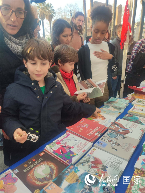 印刷精美的中國傳統(tǒng)文化叢書吸引了小游客的注意。人民網(wǎng)記者鄭彬攝