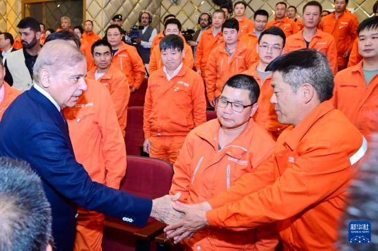 4月1日，在巴基斯坦西北部開伯爾-普什圖省達蘇，巴基斯坦總理夏巴茲（左）同達蘇水電站項目中方員工握手。新華社發(fā)（巴基斯坦新聞與廣播部下轄媒體信息部門供圖）