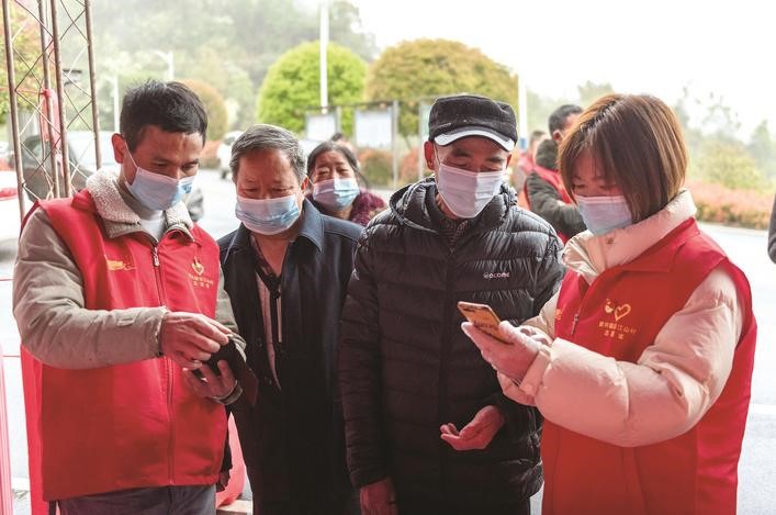 長沙縣黨員志愿者正在幫助參與核酸檢測的群眾掃描“場所碼”。劉思源 攝