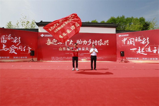 為媒體采風(fēng)團(tuán)授旗。 山東省福彩供圖