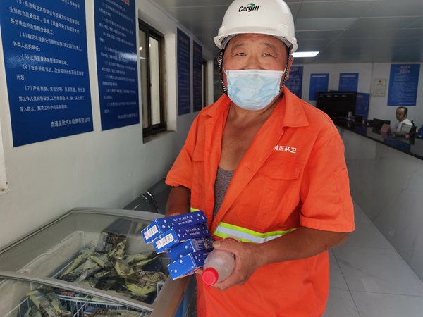 1環(huán)衛(wèi)工倪建宏小憩后，為還同事帶去冷飲。人民網(wǎng)記者王繼亮攝