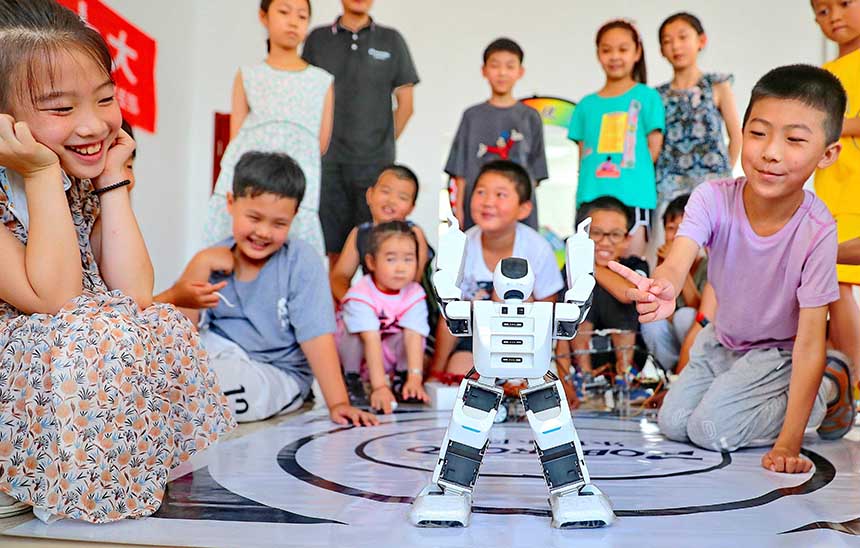 2022年7月19日，河北省秦皇島市海港區(qū)白塔嶺街道秦皇半島第二社區(qū)內(nèi)，小朋友正在觀看“機(jī)器人跳舞”。 曹建雄攝