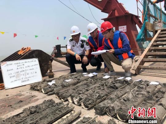 圖為勘察設(shè)計(jì)人員與海事局工作人員查看巖芯情況。　魏震 攝