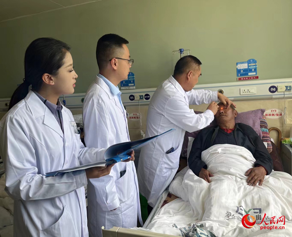 董光明（左三）帶領(lǐng)醫(yī)生對(duì)患者進(jìn)行術(shù)前檢查。人民網(wǎng)記者 杜燕飛攝