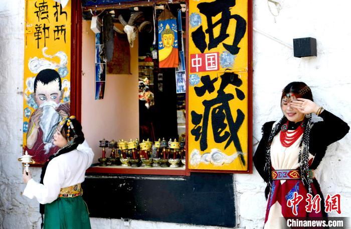 4月17日，游客身著藏式元素服裝在拉薩八廓街拍照留念。　李林 攝