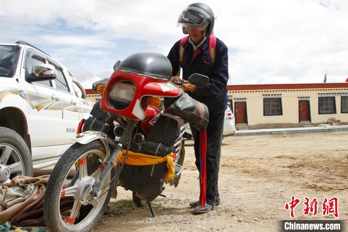 圖為白瑪準備騎摩托車巡湖?！≮w朗 攝