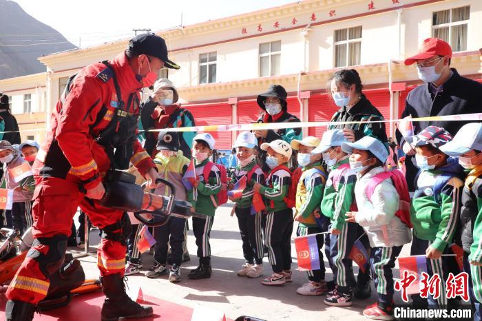 圖為消防指戰(zhàn)員為學(xué)生講解、演示先進(jìn)救援裝備?！≮w琳 攝