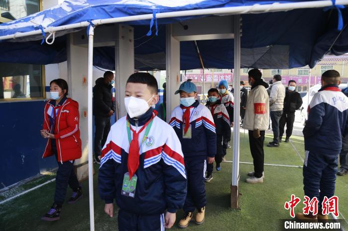 圖為學(xué)生測量體溫后進入校園?！●R銘言 攝