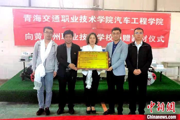 圖為李富香(中)代表學(xué)校為州縣技校捐贈(zèng)器材。(資料圖) 青海省教育廳供圖