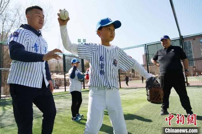 圖為教練指導(dǎo)小棒球手?jǐn)S球技術(shù)?！●R銘言 攝