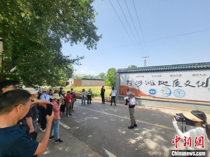 圖為中國地質(zhì)大學(xué)(北京)教授張緒教介紹村落情況。　胡友軍 攝