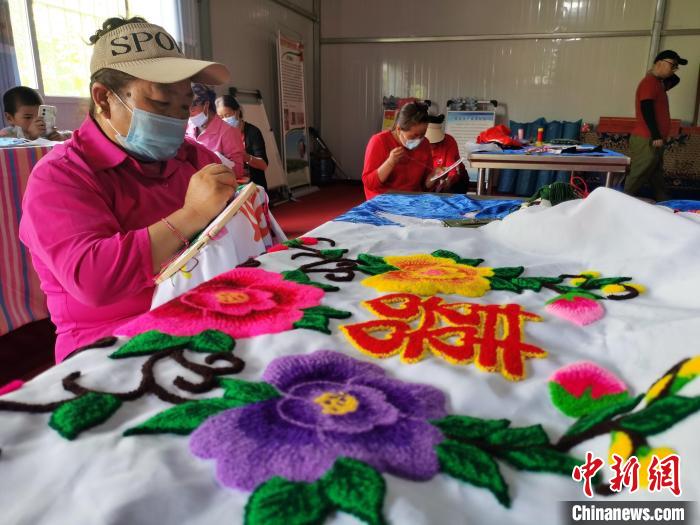 圖為婦女制作青繡?！?zhí)砀?攝