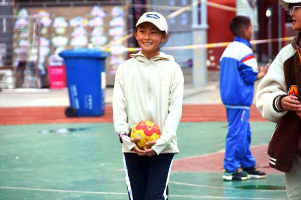 在高原上教孩子們打手球，“慢慢兒來，甭著急！”