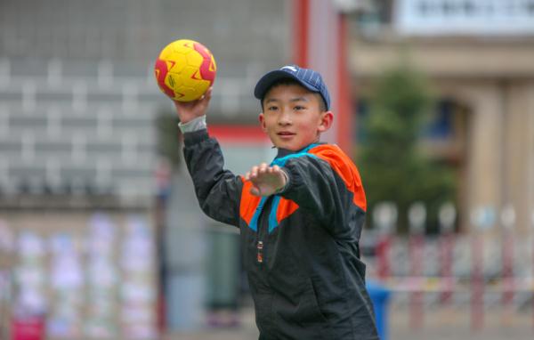 在高原上教孩子們打手球，“慢慢兒來，甭著急！”