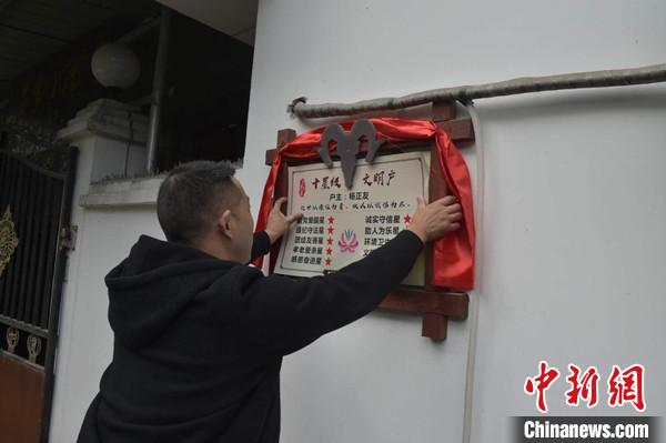 桂溪鎮(zhèn)渭溝村政府工作人員為“十星級(jí)文明戶”掛上牌匾?！钣?攝