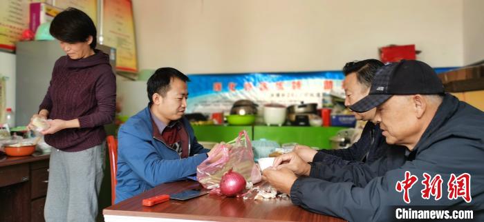 圖為扶貧路上“臨時一家人”準(zhǔn)備午餐?！∥航ㄜ?攝