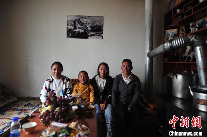 圖為8月12日，2018年7月從距那曲市色尼區(qū)城區(qū)那曲鎮(zhèn)90千米外的古露鎮(zhèn)當(dāng)桑村搬遷至城區(qū)的旦增(右一)與家人在80多平方米的新家合影(資料圖)?！垈?攝