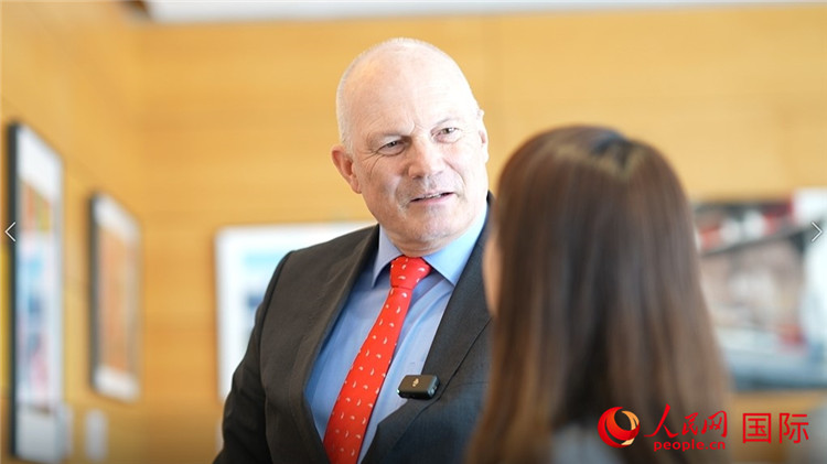 瑞士駐華大使白瑞誼介紹使館內(nèi)陳列的照片。人民網(wǎng) 彭昱凱攝