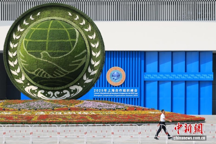 8月31日，天津，一名工作人員從2025年上海合作組織峰會主會場外的景觀花壇旁經(jīng)過。當(dāng)日，2025年上海合作組織峰會在天津舉行。<a target='_blank' href='/'><p  align=