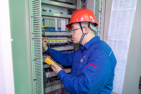 呂曉勇在保護盤柜前檢查二次回路接線情況。受訪者供圖
